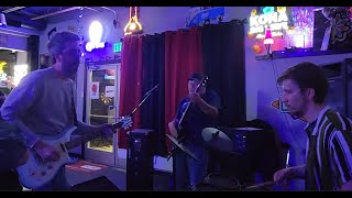 Band Next Door @ the Sand Trap. Live rock, music, drums, guitar.