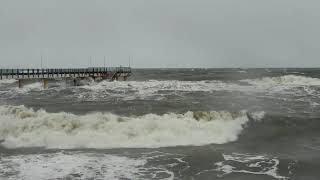 crashing waves hitting shore as a storm front rolls in
