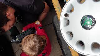 Dad and son team work on old Skoda car...