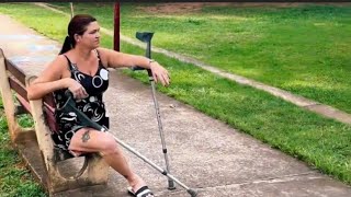 Amputee woman crutches life: walking Sightseeing at the park 