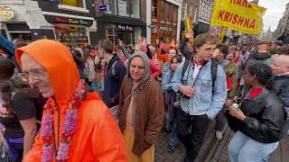 Hare Krishna aanhangers lopen zingend door Amsterdam