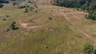 AERO 4K: Cap tourists hiking mountain trail with backpacks Aerial view ftourists mountains look