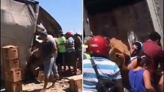 People steal boxes of beer after truck overturns in Mexico
